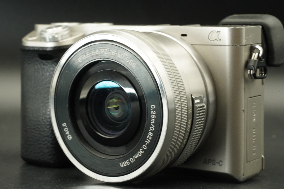 Sony a6000 Digital Mirrorless Camera Silver w/ 16-50 + 55-210mm 31032 cut #12012