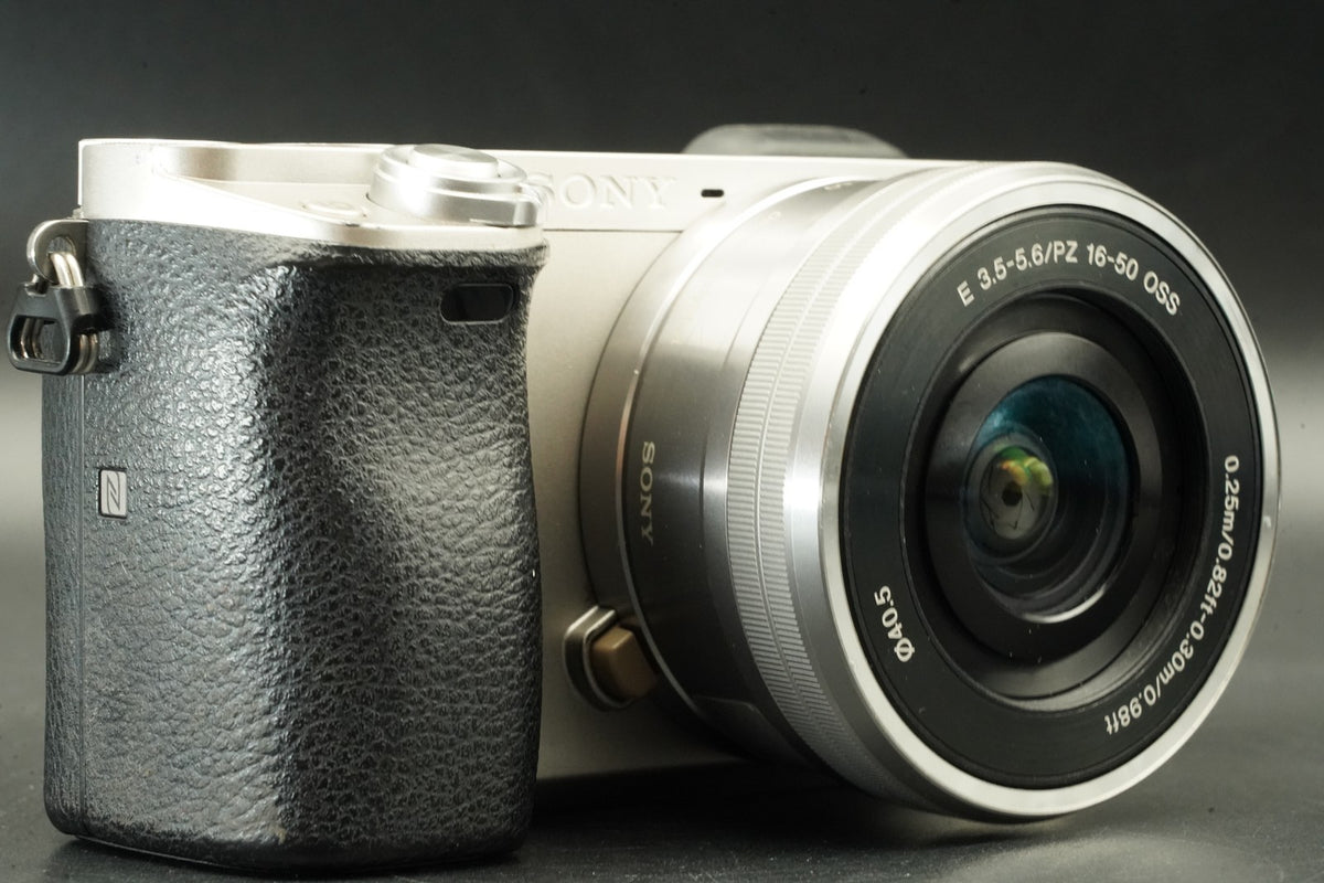 Sony a6000 Digital Mirrorless Camera Silver w/ 16-50 + 55-210mm 31032 cut #12012